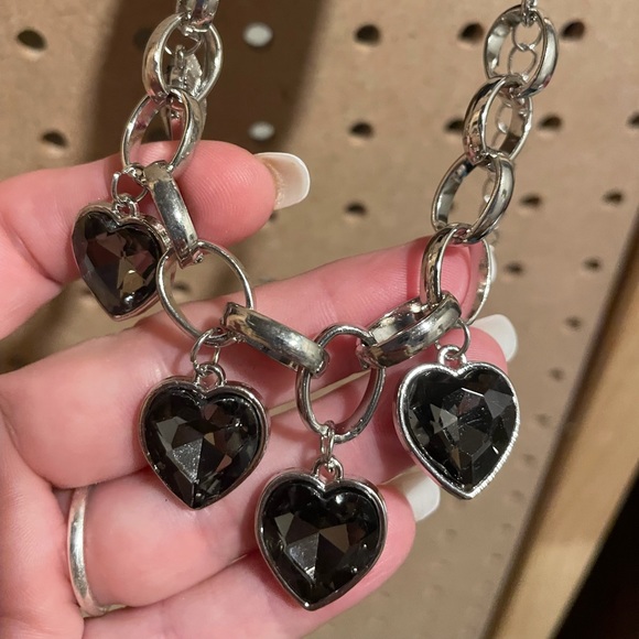 Thicker silver chain charm bracelet with four heart charms.